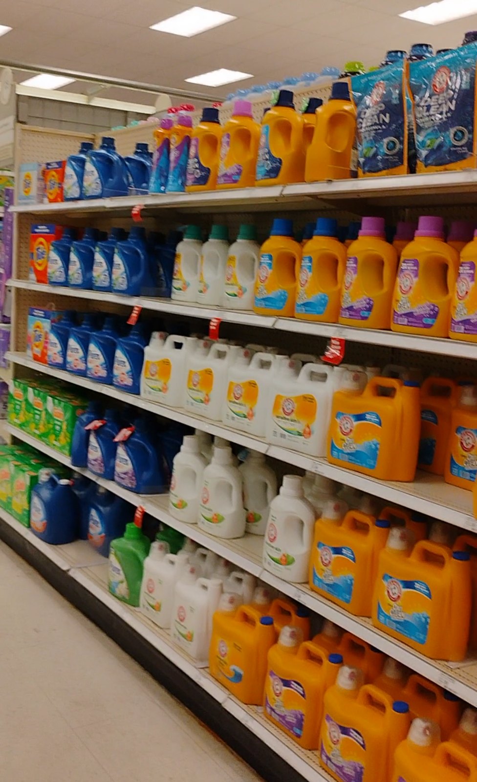 スーパーの棚に並ぶ Arm & Hammer・Tide などの洗濯洗剤