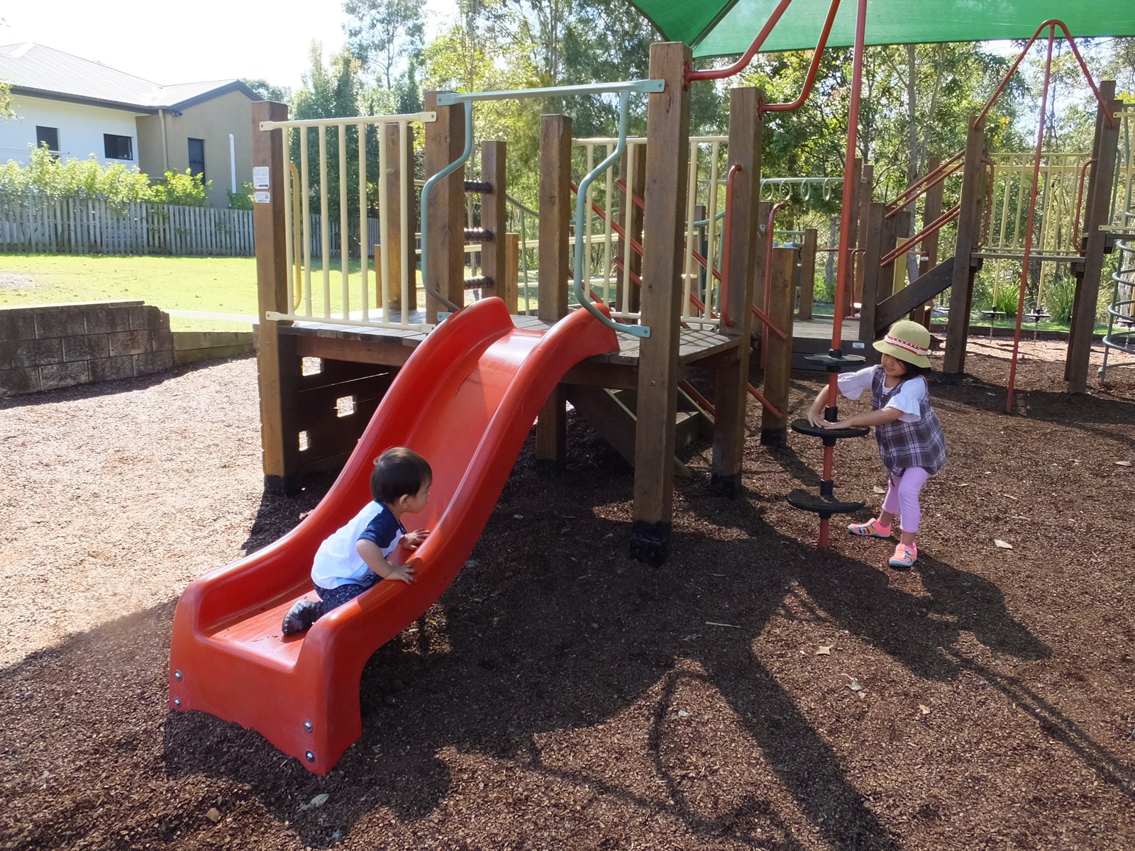 公園の遊具で遊ぶ2人の子ども
