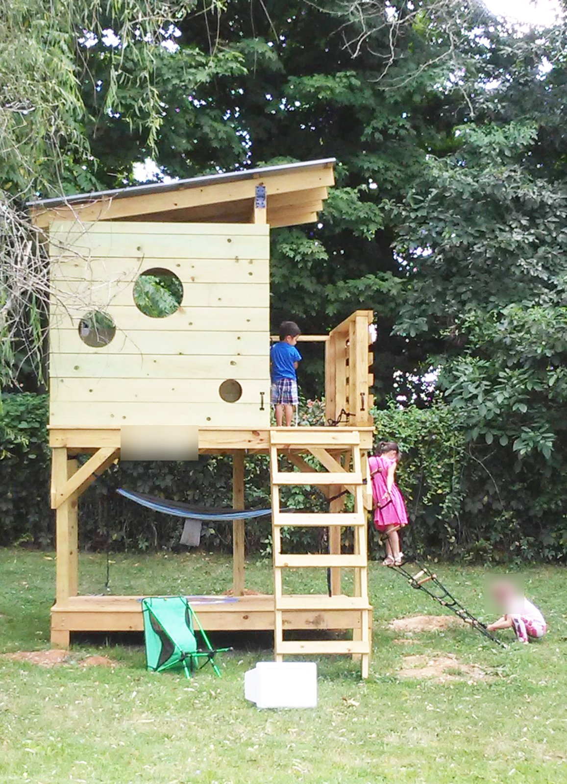 裏庭にある木の遊び小屋で遊ぶ子どもたち