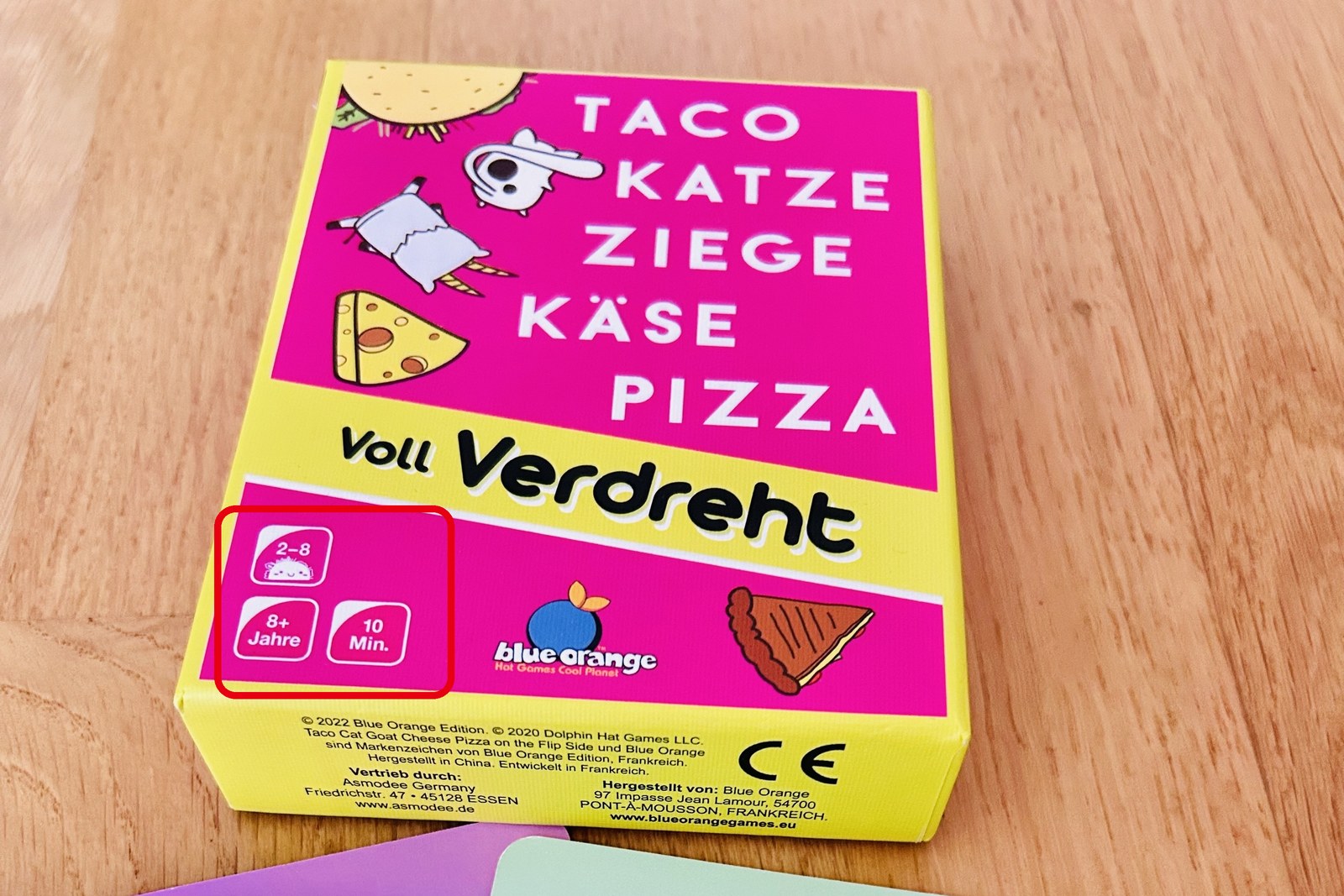 ドイツ語版の Taco Cat Goat Cheese Pizza の箱（Voll Verdreht）と、PANDA・TACO・PIZZA のカード